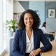 A diverse woman smiling in a bright, modern office environment.